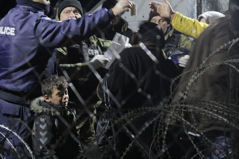 30.11.2015, Idomeni: Mazedonische Grenzer kontrollieren die Papiere einer Familie, die etwas später die Grenze passieren darf. Sie gehört zu den SIA-Geflüchteten. (Syrien, Irak, Afghanisitan) © Moving Europe