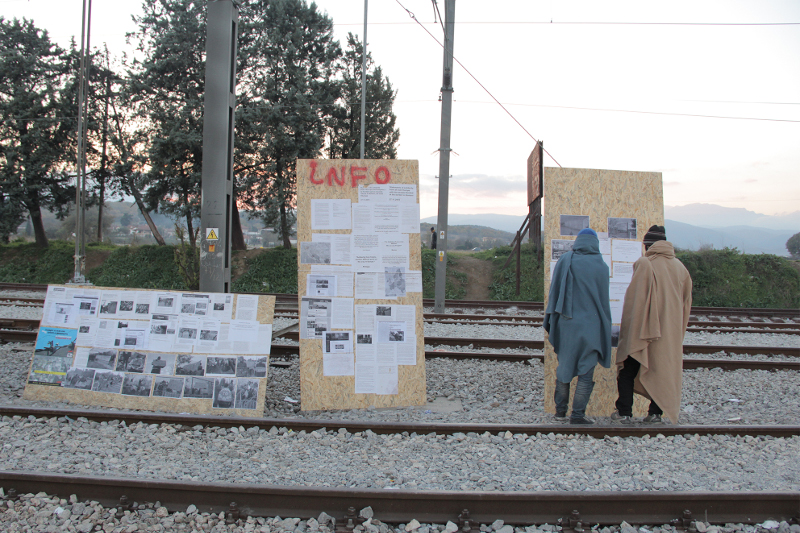 04.12.2015, Idomeni, Zwei Pakistanische Geflüchtete vor den Infowände des Moving-Europe-Bus © Moving Europe